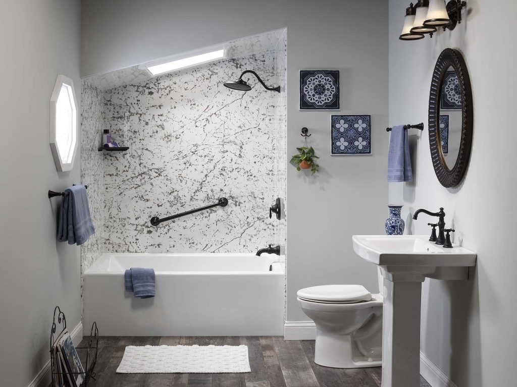 A bathroom with grey and white marble-like wall panels.