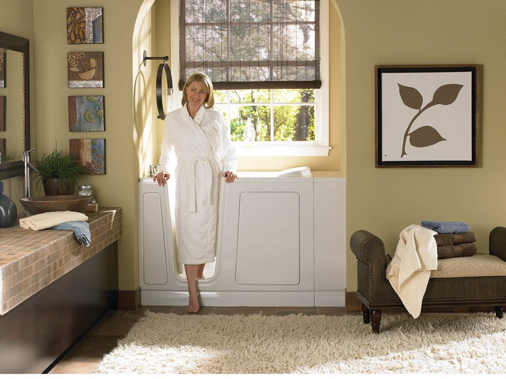 Woman stepping into bathtub with door.