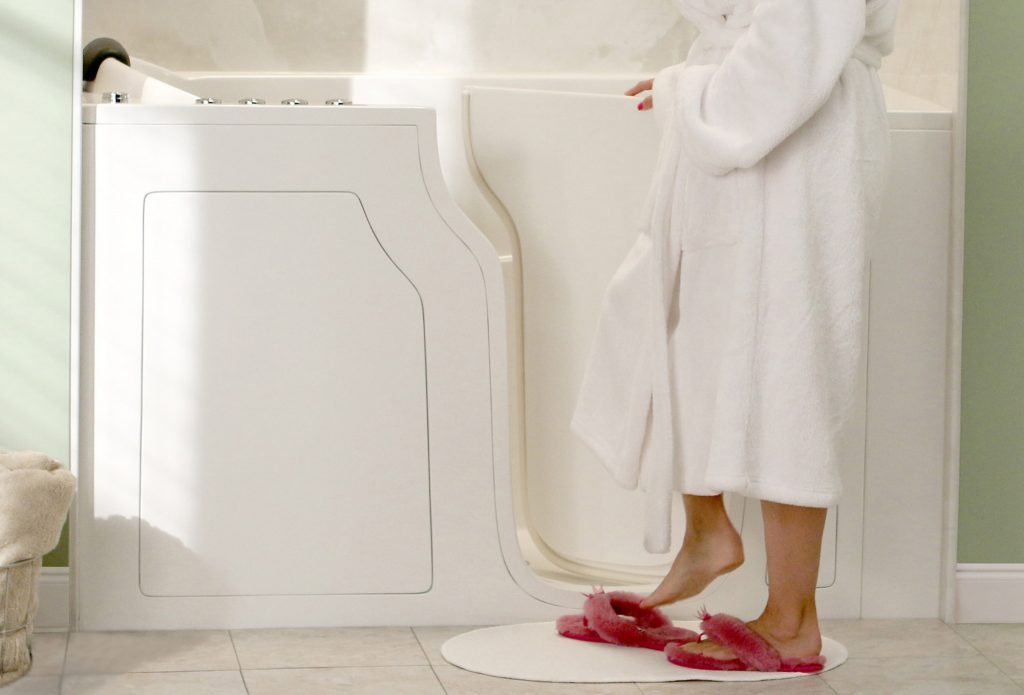 Woman stepping into a walk-in bathtub with door by Affordable 1 Day Baths