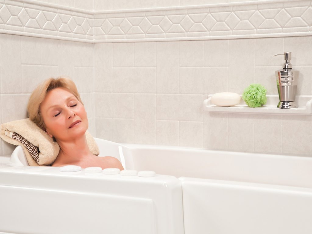 Woman relaxing in a bathtub with eyes closed.
