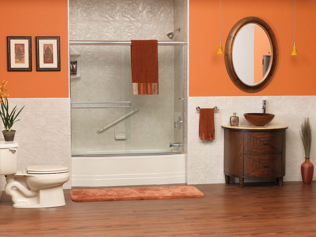 Bathroom with orange walls and a large mirror.