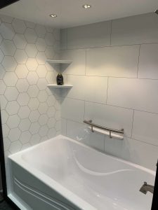 White bathtub in tiled bathroom.