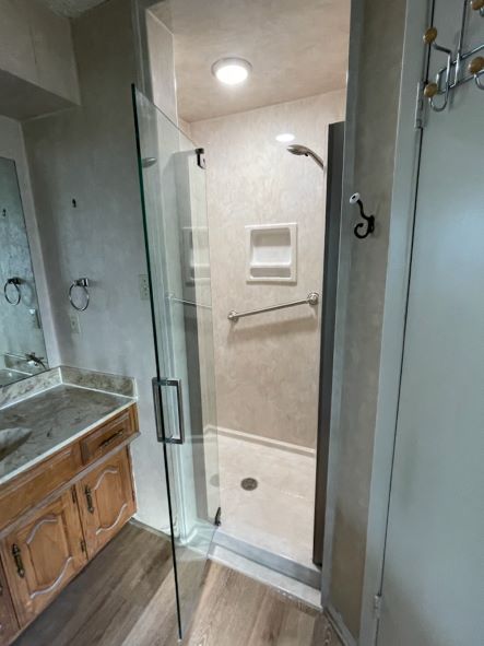 A bathroom with a glass door shower.