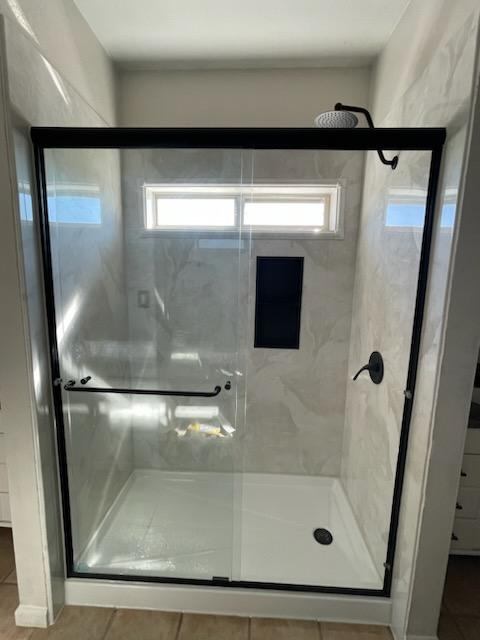Black framed shower enclosure with frosted glass.