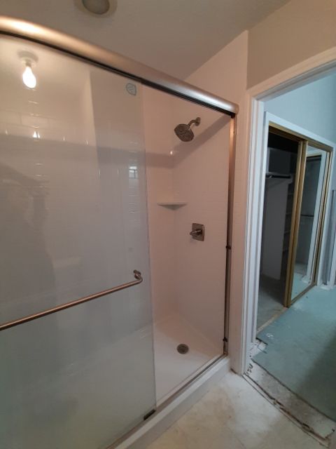 Frameless glass shower door and enclosure.