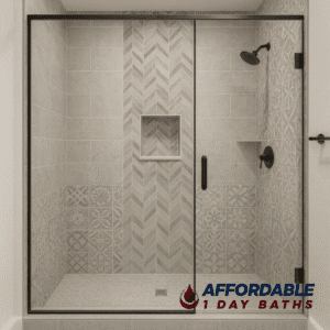 A modern walk-in shower remodel in a DFW home featuring mixed tile designs, including chevron and patterned tiles, black fixtures and glass encolure by Affordable 1 Day Baths
