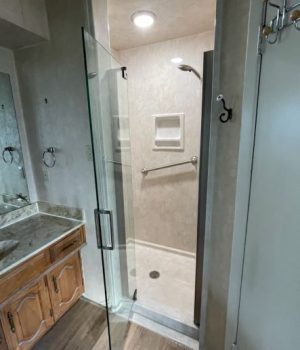 A bathroom with a glass door shower.