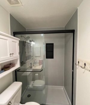 Black framed glass shower enclosure with white walls.