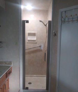 Frameless glass shower door with single handle faucet.